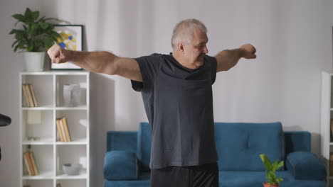 morning-exercises-at-home-cheerful-adult-man-with-grey-hair-is-training-alone-healthy-lifestyle-gymnastics-for-back
